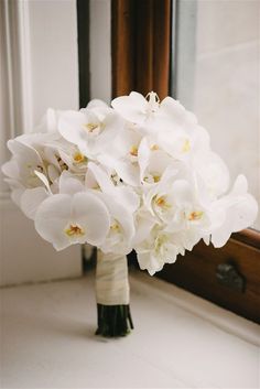 a bouquet of white flowers in front of a mirror