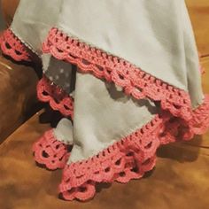 there is a pink crochet ruffle on the back of a chair with a pillow