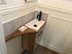 there is a sink and mirror in the corner of this bathroom with tile on the walls