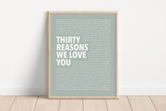 a framed poster with the words thirty reasons we love you in white on a light green background