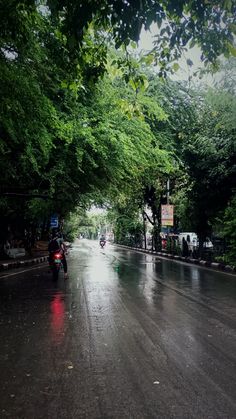 the motorcycle is driving down the wet road