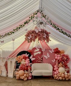 a pink and white decorated room with balloons