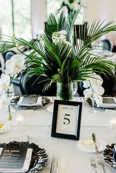 the table is set with silverware and white flowers