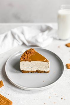 a piece of cheesecake on a plate with crackers and a glass of milk