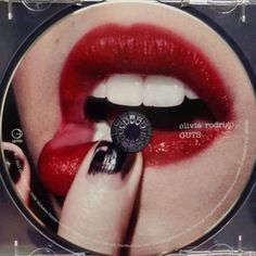 a cd with a woman's mouth and red lipstick on the cover, holding a black ring