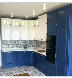 a kitchen with blue cabinets and white cupboards in the center, an oven on the far wall