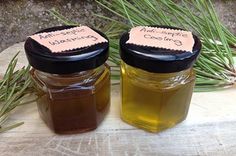 two jars filled with honey sitting on top of a wooden table