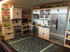 a kitchen with white cabinets and silver appliances