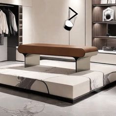 a white and brown bed in a room with clothes hanging on the wall behind it