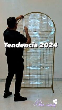 a man standing in front of a metal screen with the words tendenduta 2024 on it