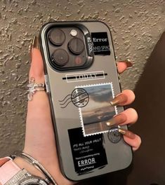 a person holding an iphone case with stamps on it and a ring in their hand