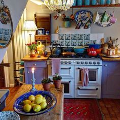 a kitchen filled with lots of counter top space and furniture next to a white stove top oven