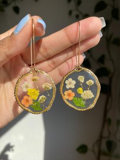 These handmade resin earrings feature multi original flower encased in a clear background, complemented by gold-tone bezel.  Perfect for adding a boho-chic touch to any outfit. lightweight for everyday use Resin Earrings Flowers, Clear Resin Earrings With Pressed Flowers, Gold Pressed Flower Earrings, Flower-shaped Resin Earrings With Pressed Flowers, Bohemian Gold Earrings With Birth Flower, Bohemian Gold Birth Flower Earrings, Clear Flower Resin Earrings, Clear Resin Flower Earrings, Gold Botanical Flower Earrings