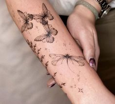 a woman's arm with flowers and butterflies on it