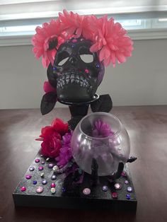 a vase with flowers in it sitting on a table next to a glass bowl filled with water