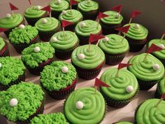 cupcakes with green frosting and red flags are arranged in a box on the table