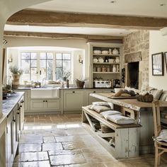 a kitchen with stone flooring and white walls