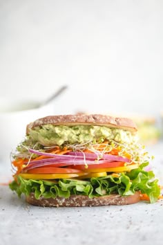 a sandwich with lettuce, carrots and avocado