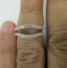 a woman's hand with a wedding band on it and the ring is made out of white gold