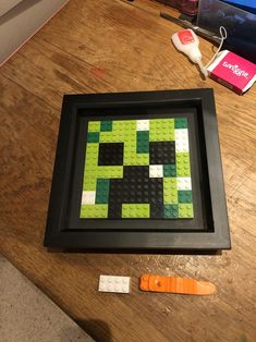 a wooden table topped with legos and a black framed object on top of it