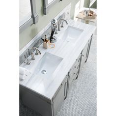 a double sink vanity in a bathroom with marble counter tops and chrome faucets