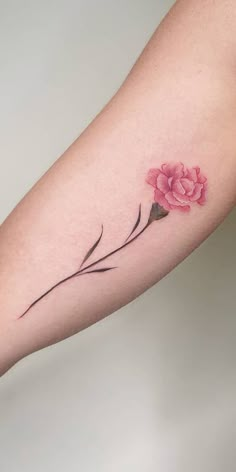 a woman's arm with a pink flower tattoo on the left side of her arm