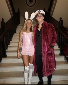 a man and woman dressed up in bunny ears standing next to each other on stairs