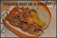 a close up of a sandwich on a plate with words above it that reads italian beef in a bucket