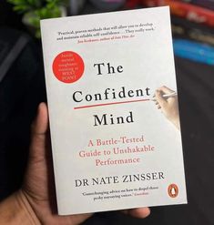 a person holding up a book in their hand with the title, the confident mind