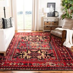 a living room filled with furniture and a red rug