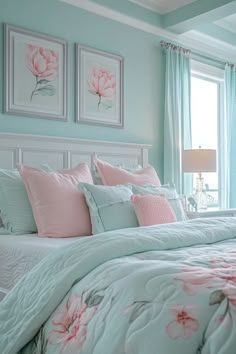 a bedroom with blue walls and pink flowers on the comforter, along with two framed pictures above the bed