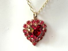 Elegant Red Crystal Heart Crystal Necklace Surrounded with 15 small Light Red (Light Siam) Crystals.  Set in a gold plated prong setting. I used a  11x10mm crystal heart in Siam Red Heart. Please choose the size of the chain you prefer in : 16 to 20 inches. The pendant is 1 inches from the top of bail - see 2nd picture for size. ArtistInJewelry on Etsy offers Fine Crystals - Vintage Czech - Germany and Japanese Rhinestones and Glass to create my pieces. My Handmade Jewelry is inspired by Art Dec Red Heart Necklace For Valentine's Day Party, Red Heart Cut Necklace For Wedding, Red Double Heart Necklace For Wedding, Red Heart Cut Necklace For Party, Wedding Double Heart Red Necklace, Wedding Red Double Heart Necklace, Heart Necklace Gold, Red Heart Necklace, Crystal Heart Necklace