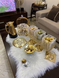 a table topped with lots of gold and silver items on top of a white rug