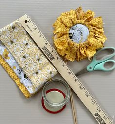 scissors, measuring tape, and fabric sitting next to each other on top of a table