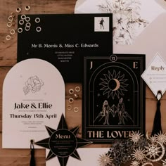 the wedding stationery is laid out on a wooden table with paper and other items