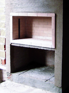 an empty shelf in the corner of a room that is made out of bricks and cement