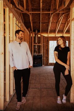 a man standing next to a woman in a room with wooden framing on the walls