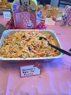 a pan filled with macaroni and cheese on top of a pink table cloth