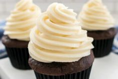 three chocolate cupcakes with white frosting on a blue and white plate,