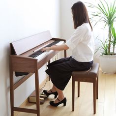 a woman sitting at a piano playing it