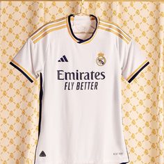 the real madrid jersey is displayed in front of a wall with yellow and white patterns