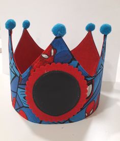 a blue and red paper crown with pom poms on it's sides