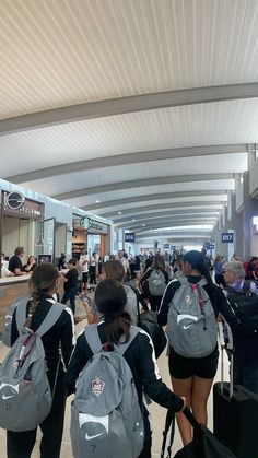 several people with backpacks walking through an airport