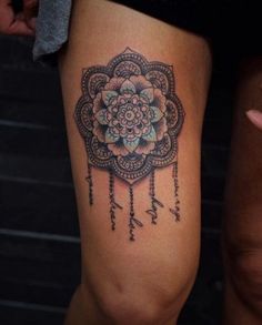 a woman's leg with a tattoo on it that has a flower in the center