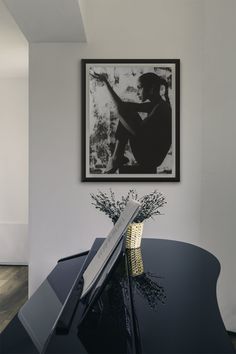 a black and white photo hanging on the wall above a piano