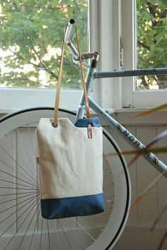 a white and blue bag hanging from the side of a bike