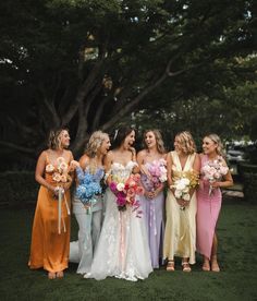 a group of women standing next to each other on top of a lush green field