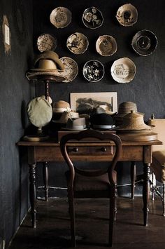 a room with many plates on the wall and a wooden table in front of it