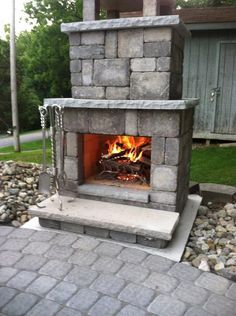 an outdoor fireplace in the middle of a yard