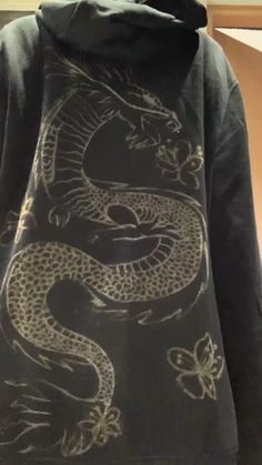 a black hoodie with a dragon on it